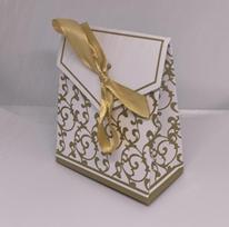 Balta dovanų dėžutė su auksiniais ornamentais ir kaspinėliu