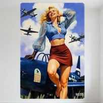 Senovinis karo meto Pin-Up stiliaus metalinis skardinis ženklas - Besišypsanti šviesiaplaukė moteris su mėlynu bliusku ir rudu sijonu, besiremianti į karinį lėktuvą, 20x30cm（7.8x11.8inch）