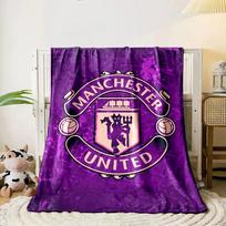 A purple background with a Manchester United crest in the center. for all seasons blanket lunch break throw gift 80cm x 120cm