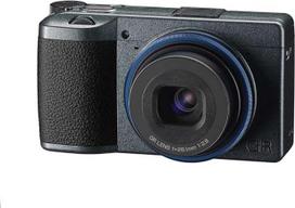 "Ricoh GR IIIx Urban Edition", metalinės pilkos spalvos korpusas su tamsiai mėlynu žiedu, skaitmeninis kompaktiškas fotoaparatas su 24 MP APS-C CMOS jutikliu, 40 mm F2,8 GR objektyvu (atitinka 35 mm formatą)