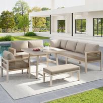 Rankų darbo lauko kampinė sofa su smėlio spalvos pagalvėlėmis ir staliuku su medžio imitacija