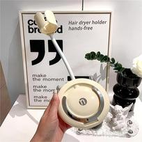 Universal seamless wall-mounted hair dryer holder, no drilling needed. 360° adjustable, hands-free plastic stand, essential bathroom accessory. kreminė