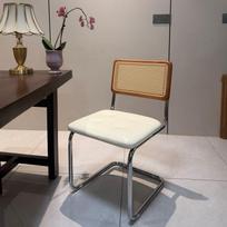 Elegantiškai pagaminta pintų rotango valgomojo kėdė be porankių, retro kaimiško stiliaus, puikiai tinkanti kavinėms, svečių namams ir vintažinei aplinkai.