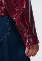 Moteriška bordo spalvos striukė su faktūriniu paviršiumi ir diržu
