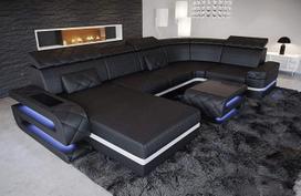 „Bologna“ sofa kaip gyvasis kraštovaizdis – U formos odinė sofa su USB jungtimis galvūgaliuose ir apšvietimu; dizainerio sukurta odinė sofa su daiktų laikymo erdve (pufas kairėje (žiūrint į sofą), juoda ir balta)